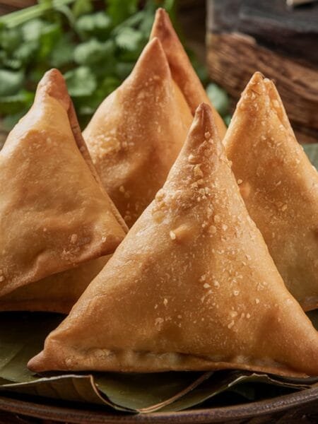 A plate of our crispy samosa recipe served with tamarind and mint chutneys.
